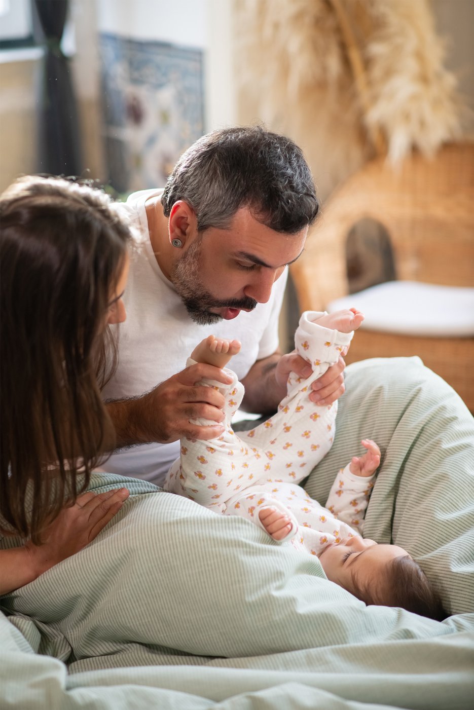 happy-couple-playing-with-baby-son-bed